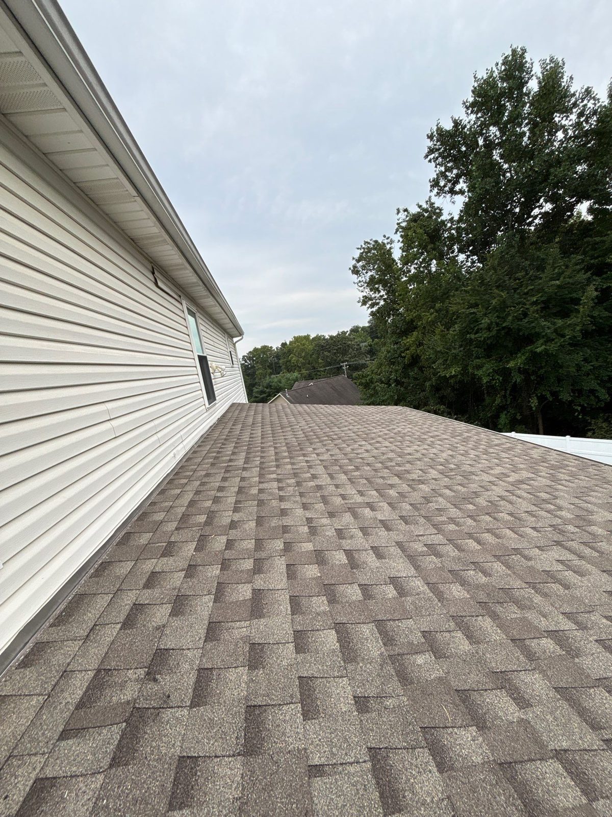 New architectural shingle roof alongside vinyl siding in Karns, TN by McGuire Roofing