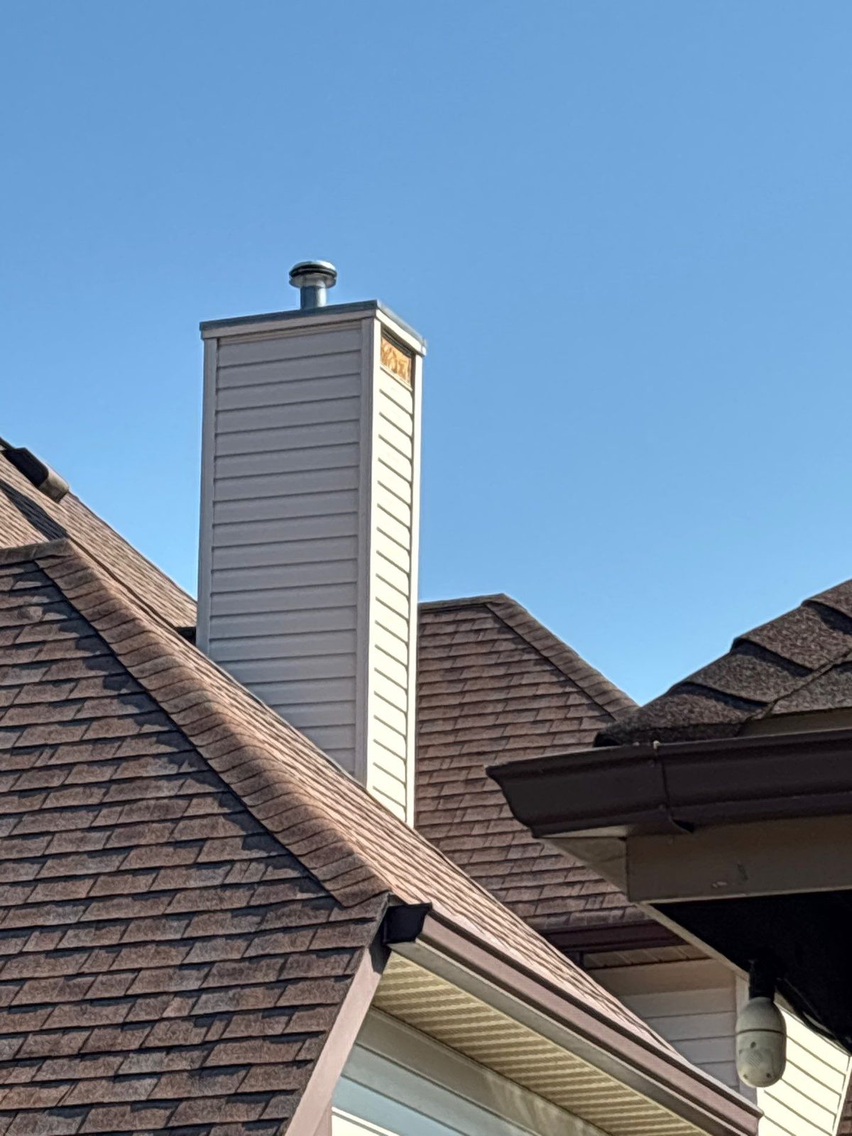 Brown architectural shingle roof with chimney on a home in Knoxville, TN by McGuire Roofing